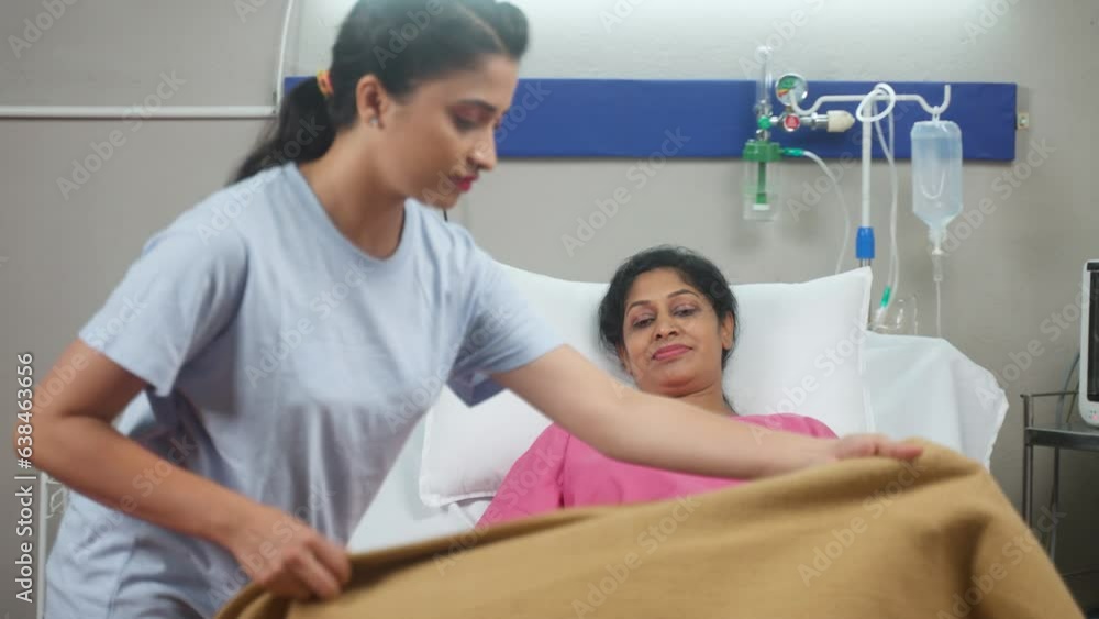 Indian daughter covering blanket to sick sleeping mother at hospital ward- concept of family caring, medical treatment and relationship bonding Indian daughter covering blanket to sick sleeping mother at hospital ward- concept of family caring, medical treatment and relationship bonding