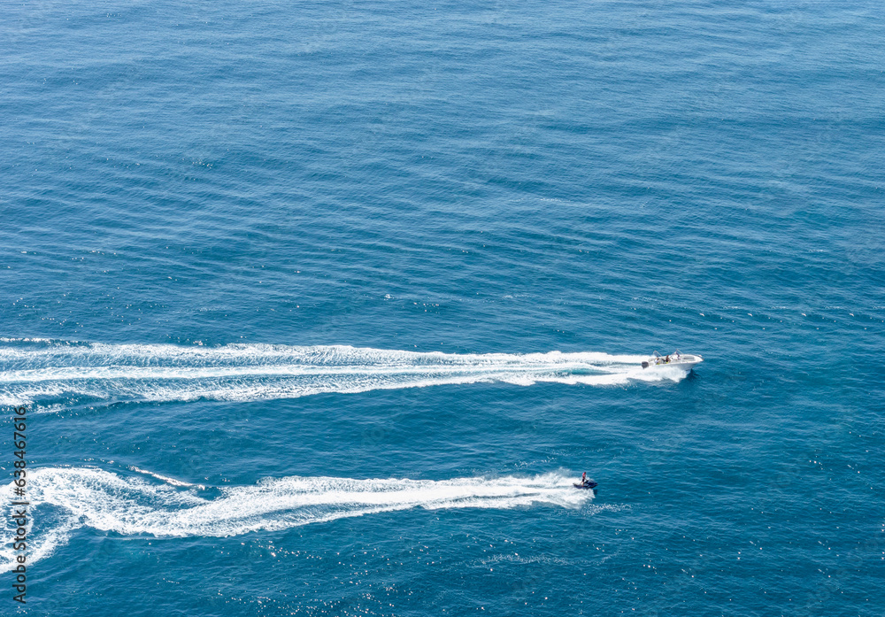JET SKI AND SMALL MOTOR BOAT SAILING PARALLEL AT CABO LA NAO, JAVEA, ALICANTE, SPAIN JET SKI AND SMALL MOTOR BOAT SAILING PARALLEL AT CABO LA NAO, JAVEA, ALICANTE, SPAIN