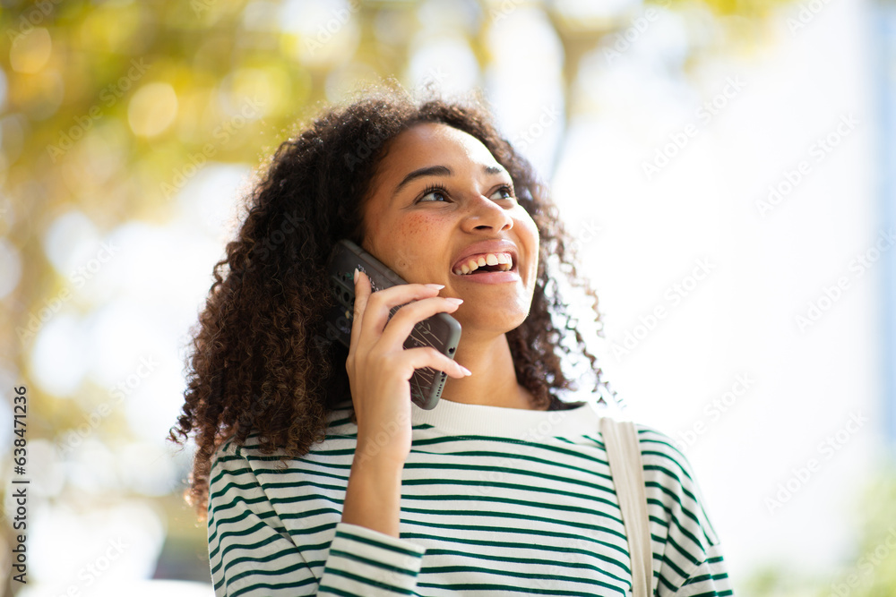 smiling young woman talking with cellphone and looking up smiling young woman talking with cellphone and looking up