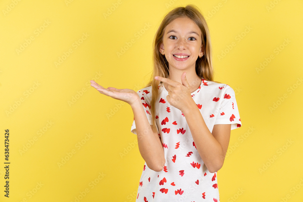 Beautiful teen girl pointing and holding hand showing adverts Beautiful teen girl pointing and holding hand showing adverts