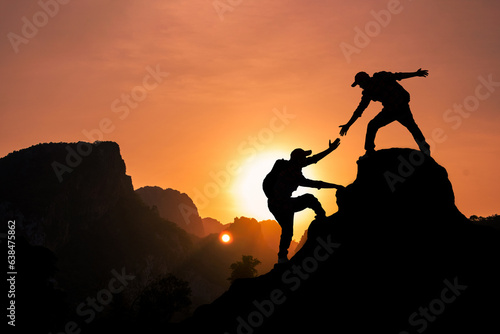 Amidst the echoing rays of sunlight, the mountain climber is extending a helping hand to pull their friend up to the mountaintop summit.