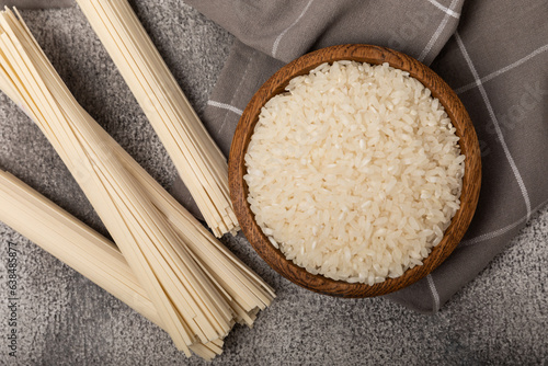 Funchoza.Dried raw rice noodles and rice on a textured background.Noodles with rice flour. Diet food. Healthy food. Place for text. Place for copying.