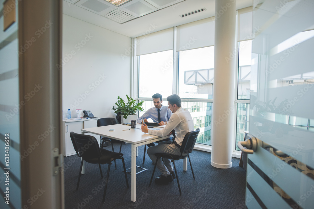 Fototapeta premium Two multiethnic millennials businessmen using computer working together