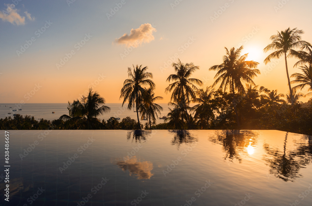 Exotic landscape view with palm trees reflected in surface of water in pool on tropical paradise Koh Tao island during the orange sunset