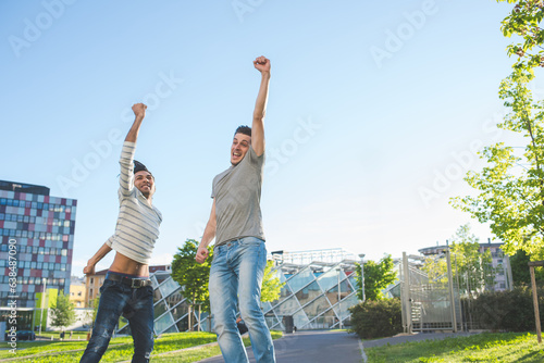 Two young multiethnic men outdoors jumping