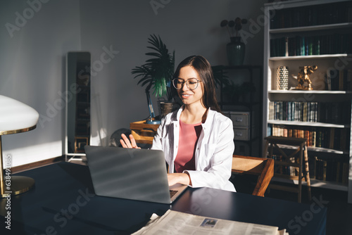Smiling female physician having video call on computer photo