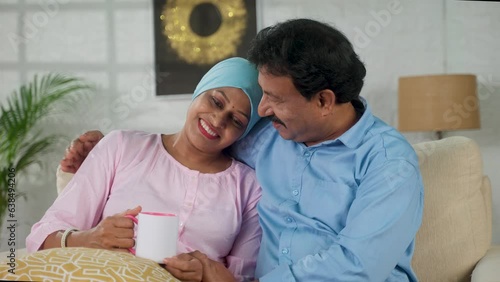 Happy indian recovered cancer patient with spending time with husband by embracing at home - concept of rehabilitation, communication or affection and family togetherness.