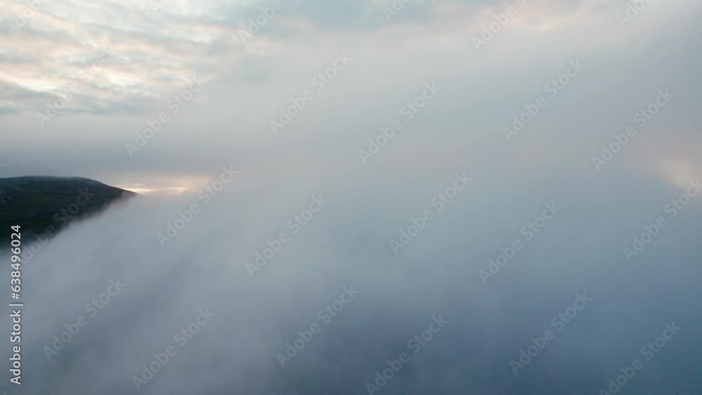 aerial drone flying through the clouds revealing Nipfjallet mountain scenery and golden sunrise in Idre Sweden aerial drone flying through the clouds revealing Nipfjallet mountain scenery and golden sunrise in Idre Sweden