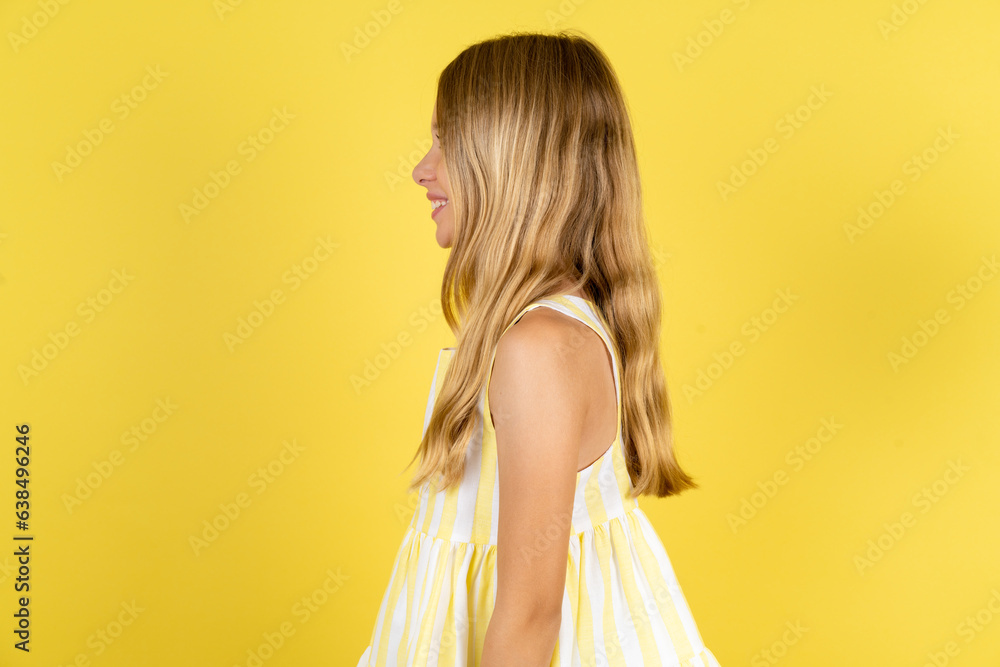 Profile portrait of nice Beautiful caucasian kid girl wearing yellow dress look empty space toothy smile Profile portrait of nice Beautiful caucasian kid girl wearing yellow dress look empty space toothy smile