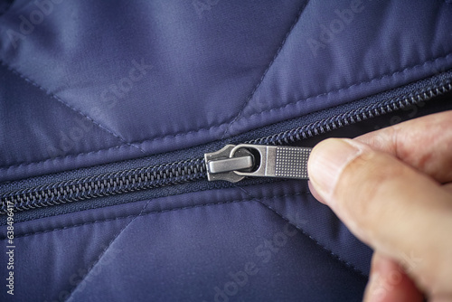 Closeup shot of a zipper on a blue jacket. Unzip a zip photo