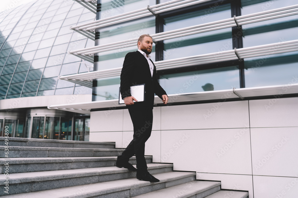 Confident businessman walking downstairs in city