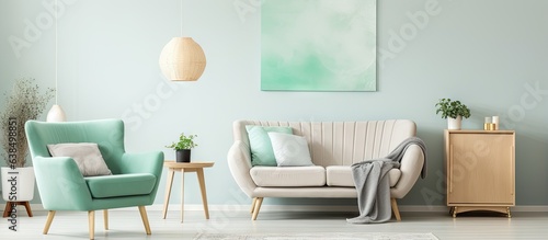 Beige sofa near designer lamp with gold painting above in living room with scandi carpet and mint chair