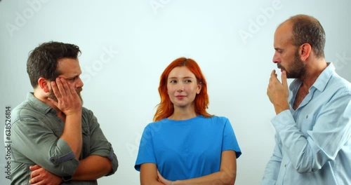 A group of coworkers, a woman and two men, are in a studio, looking at the camera. The woman suddenly farts, and the men make disgusted facial expressions and move away from her.  photo