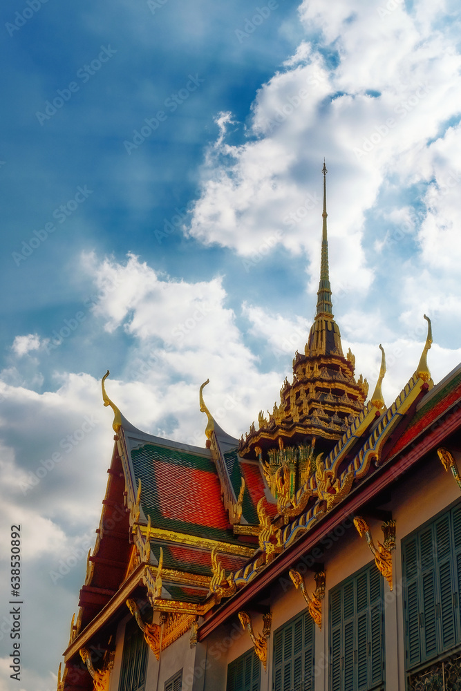Against a backdrop of clear blue sky, an exquisite Thai temple with a towering spire embodies the splendor of Asian architecture.