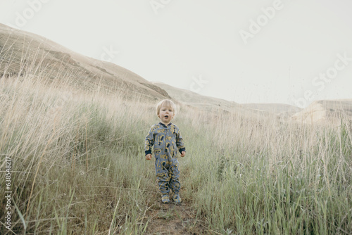 A young boy walks through the grass during a camping trip in Oregon.