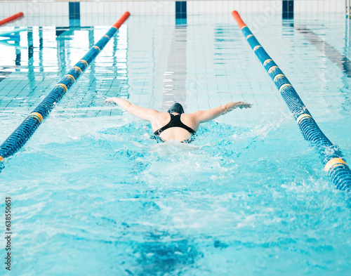 Sports  swimming pool and woman athlete training for a race  competition or tournament. Fitness  workout and back of female swimmer practicing a cardio water skill for exercise  speed or endurance.