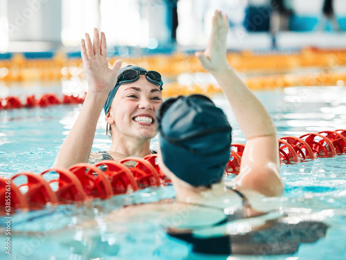 Fitness, swimmer and women with high five, celebration and achievement with workout, wellness and winning. Exercise, winner or champion in a pool, celebration or support with success, sports or smile photo