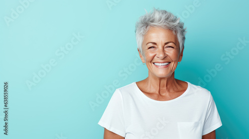 Senior female standing in front of camera in white T-shirt   isolated on blue background