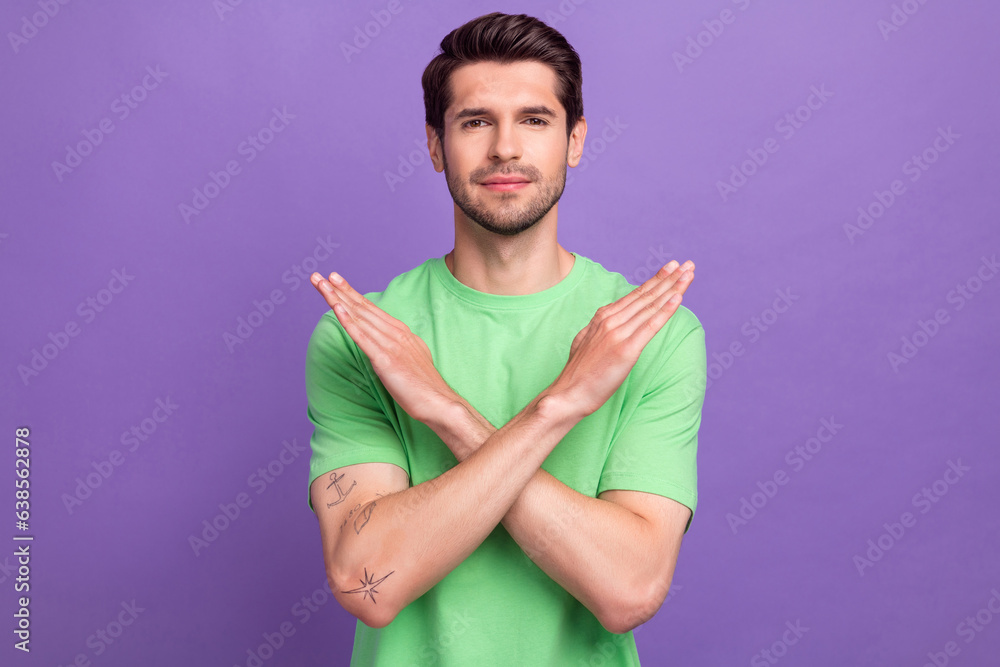 Portrait of confident handsome guy with bristle wear green t-shirt hold arms crossed show stop isolated on violet color background Portrait of confident handsome guy with bristle wear green t-shirt hold arms crossed show stop isolated on violet color background