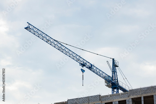 Obraz na płótnie Crane on the background of a cloudy sky. Construction of storey buildings. w salonie