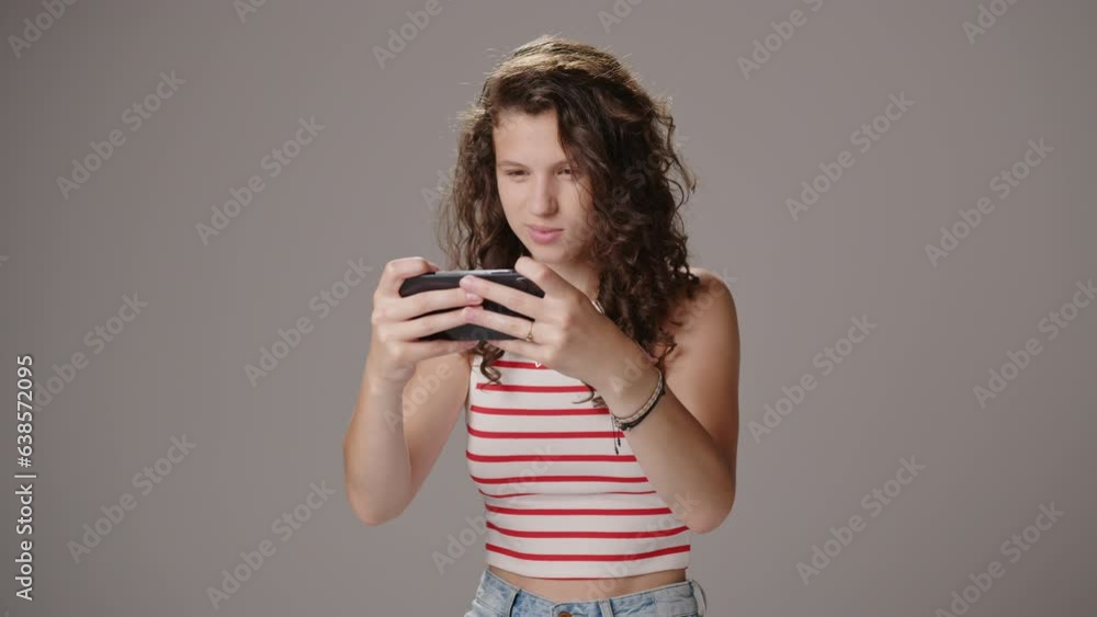Animated young caucasian lady playing games on smartphone, medium shot Animated young caucasian lady playing games on smartphone, medium shot