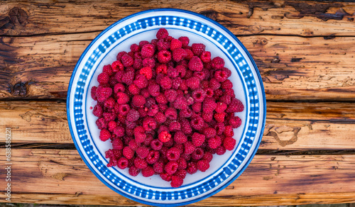 Wallpaper Mural bowl of red raspberries on wooden bench in a garden Torontodigital.ca
