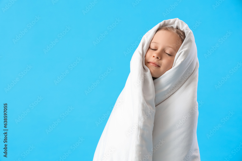 Little girl wrapped in blanket on blue background Little girl wrapped in blanket on blue background