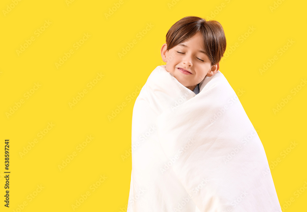 Little boy wrapped in blanket on yellow background Little boy wrapped in blanket on yellow background