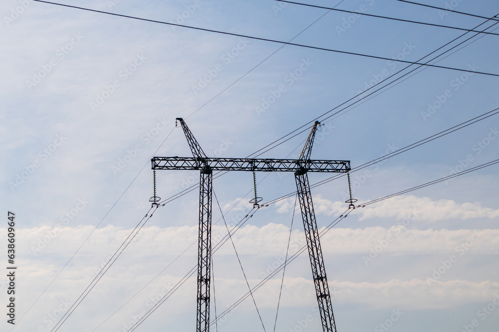 High voltage power line pole, pylon. Power line mast on a blue sky background. Electrification, energy concept