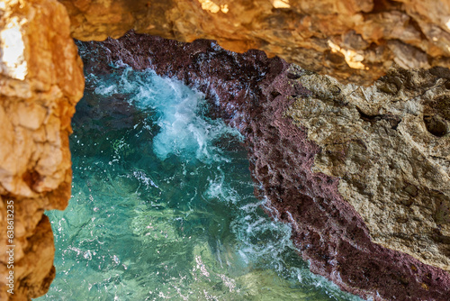 Sea water breaks on the rocks inside the grotto.