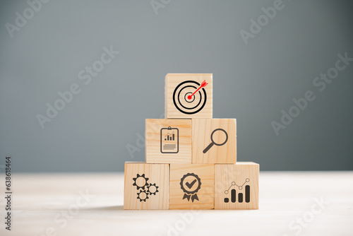 Business target concept on wooden block cude step. Action Plan and Goal icons symbolize success. Project management and company strategy on a table. Financial growth is the objective.