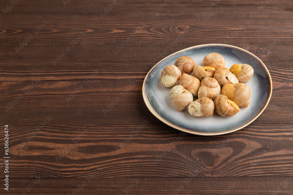 Grape (Burgundy) snails with butter and cheese on brown wooden, side view, copy space. Grape (Burgundy) snails with butter and cheese on brown wooden, side view, copy space.