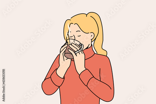 Woman drinks hot tea to keep warm and quench thirst after walk in park in cold winter weather. Girl in sweater holds mug of tea and enjoys taste and aroma of drink made from natural herbs