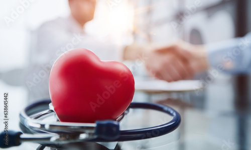 Stethoscope and red heart on wooden table. Cardiology concept