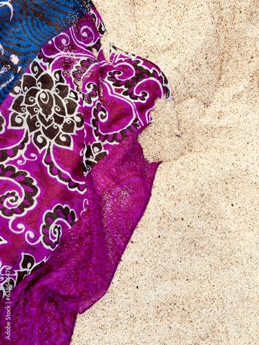 Colorful scarf on beach sand, natural background