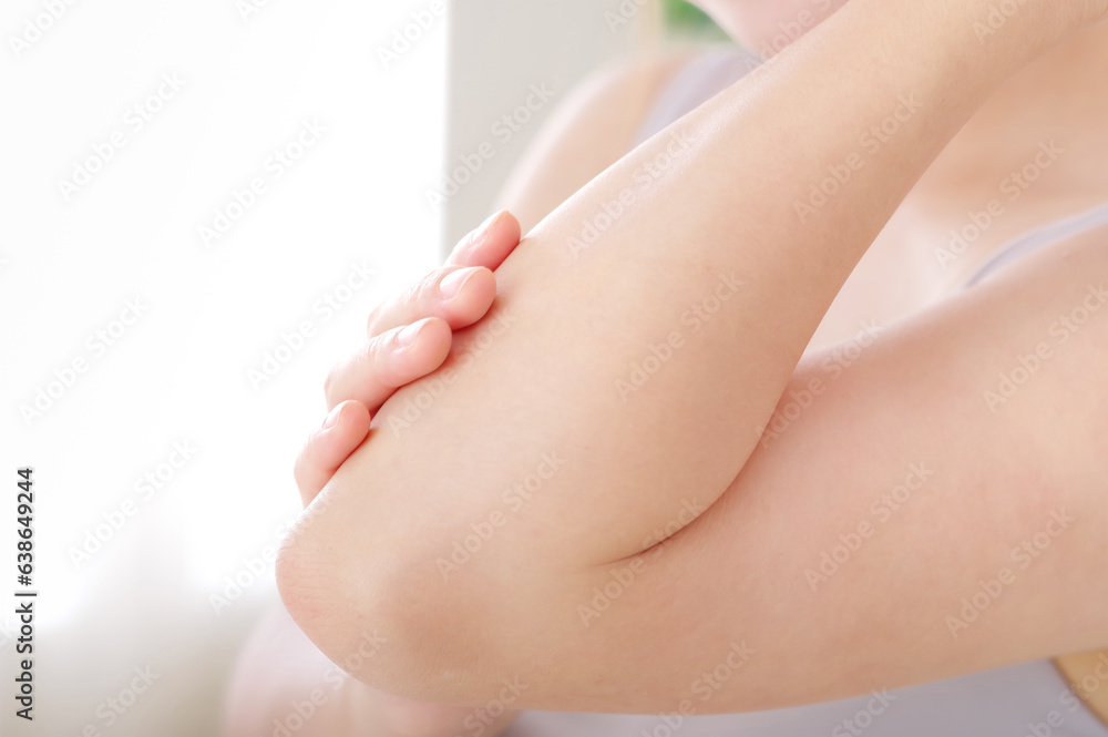 腕を触る若い女性 腕を触る若い女性