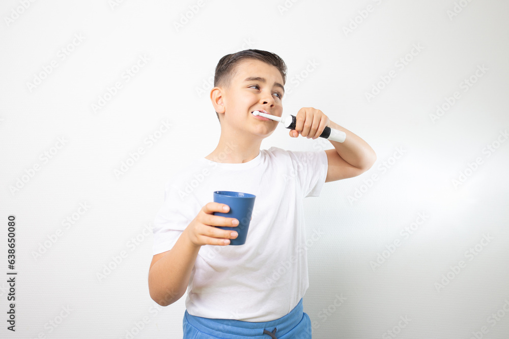 portrait of happy child kid boy brushing teeth with electric toothbrush on white background portrait of happy child kid boy brushing teeth with electric toothbrush on white background