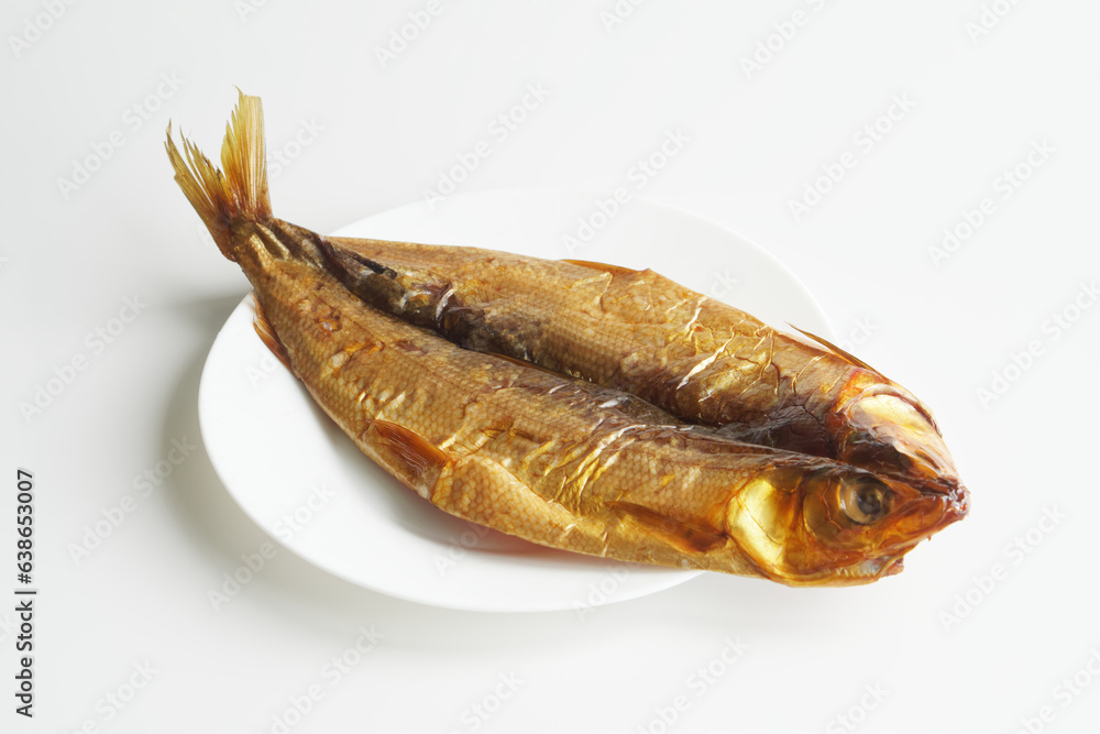 Prepared gutted smoked Baikal omul in a white plate on a white background. Rare fish delicacy - omul. Photo. Selective focus. Copy space. Prepared gutted smoked Baikal omul in a white plate on a white background. Rare fish delicacy - omul. Photo. Selective focus. Copy space.