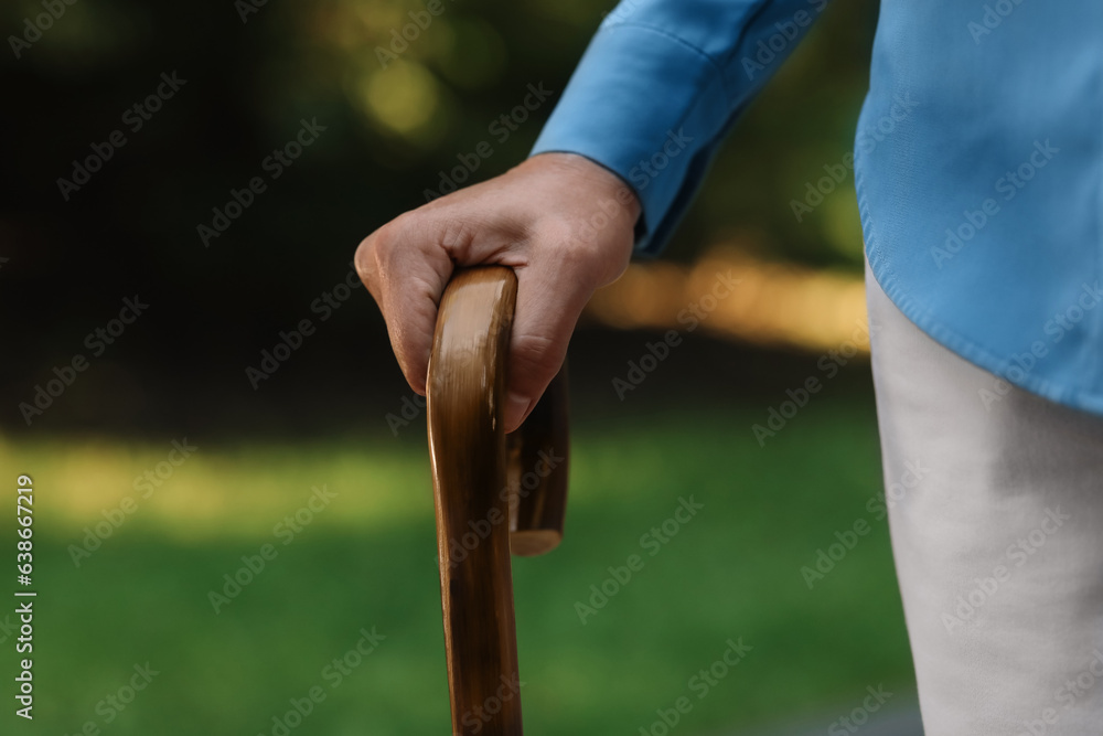 Senior woman with walking cane outdoors, closeup