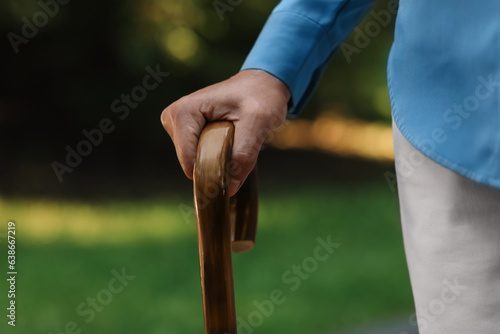 Senior woman with walking cane outdoors, closeup © New Africa
