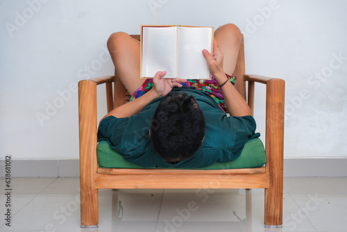 Man sitting alone on the sofa watching TV with very quiet and nervous facial expression photo