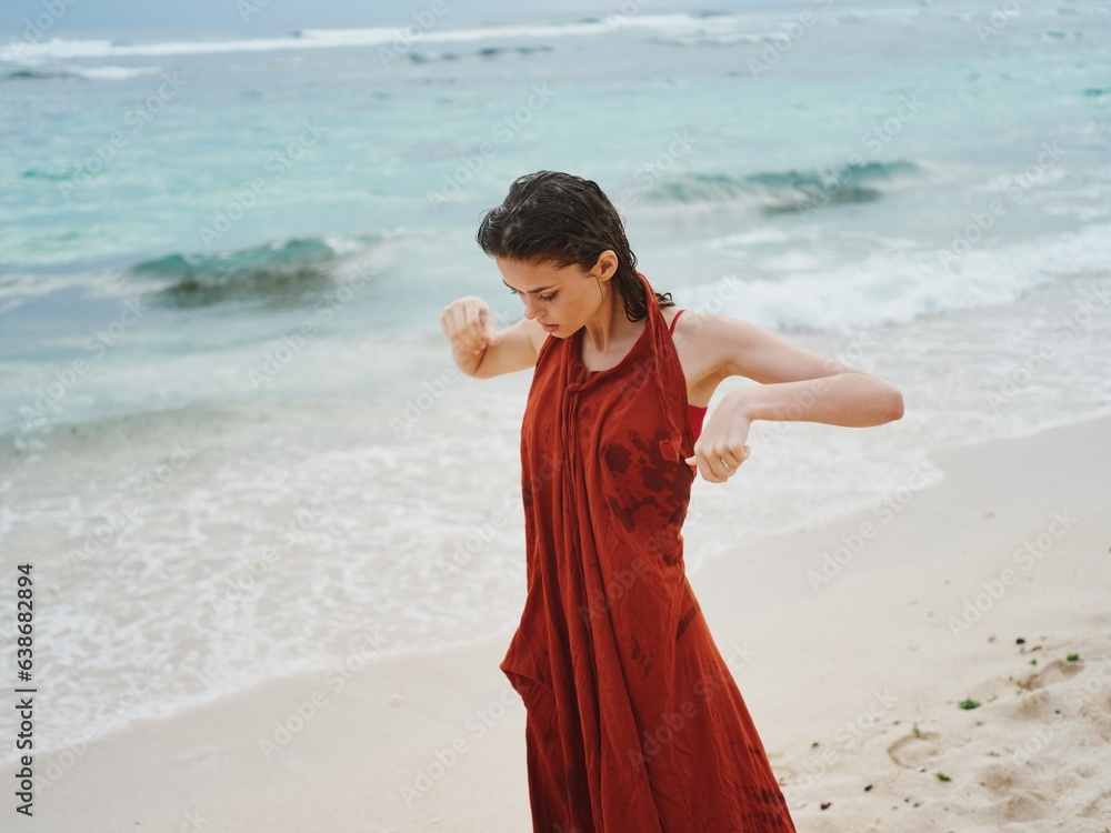 Woman freezes after swimming in the ocean and puts on clothes in cloudy overcast weather Woman freezes after swimming in the ocean and puts on clothes in cloudy overcast weather