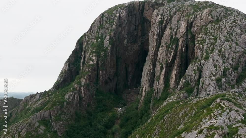 Dark eroded opening hole through Torghatten mountain; drone orbit Dark eroded opening hole through Torghatten mountain; drone orbit