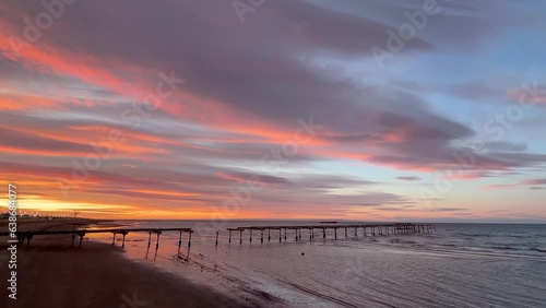 Early Winter calm sunrise in Puerto Arenas in Chilean Patagonia with slow waves and dramatic orangy clouds, Chilean Patagonia 2023, Chile photo