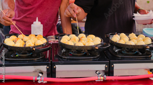 Photography Close up shot of guys preparing Takoyaki, very famous Japanese street food in In