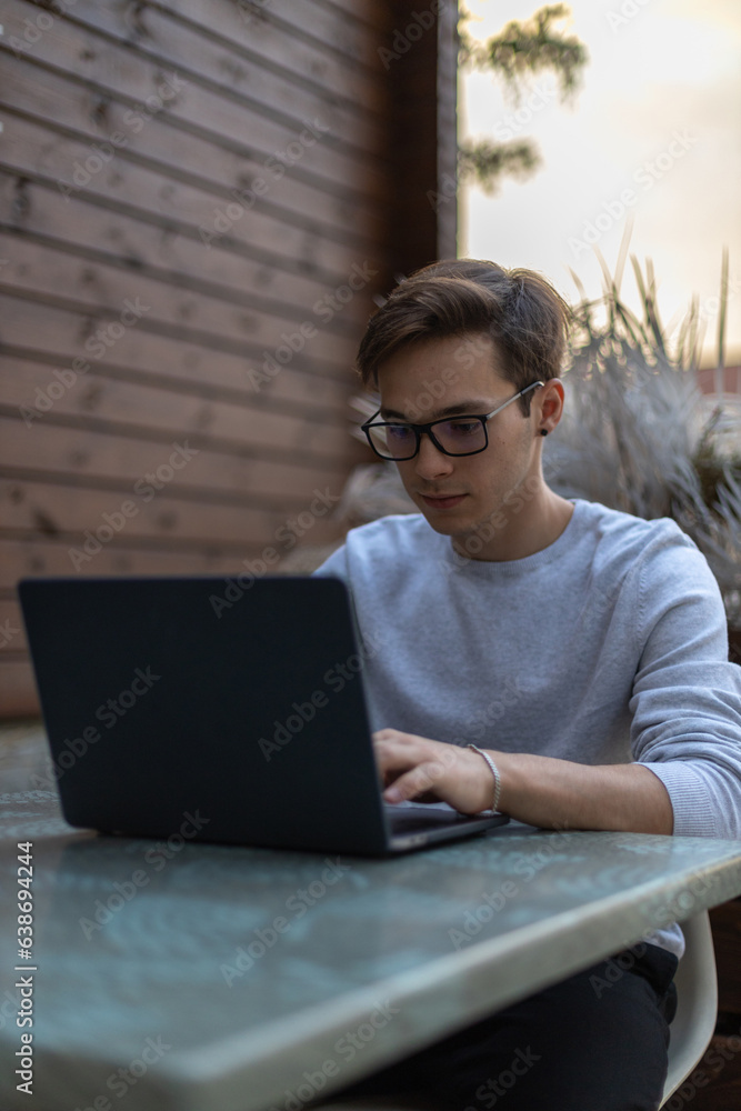 A student is working at a laptop in the park. A student is working at a laptop in the park.