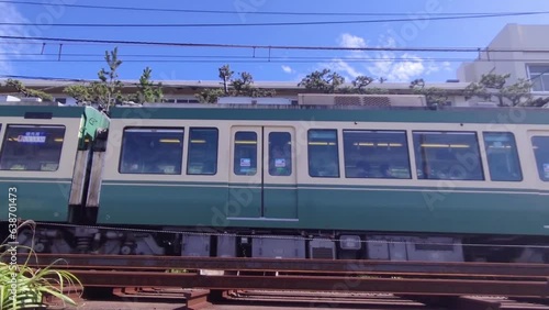 高校の校舎の前を走るレトロな電車。
