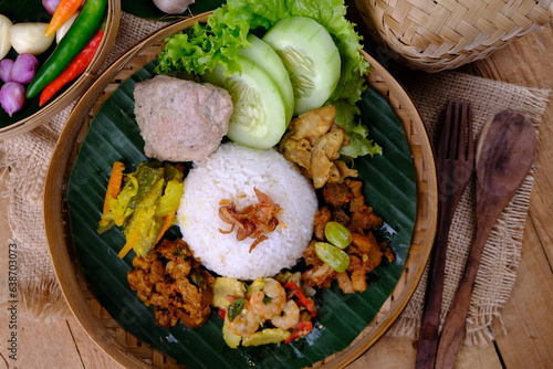 Nasi Berkat Pekalongan. is rice with side dishes of fried chicken, stir-fried spicy vegetables, fresh vegetables. nasi kenduri. ayam santan, sambal goreng, tumis sayur, acar kuning. Indonesian food