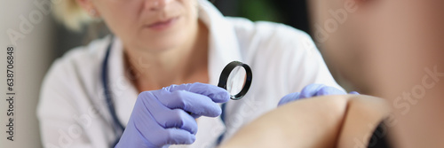 Female doctor examining male patient skin at consultation in medical clinic.