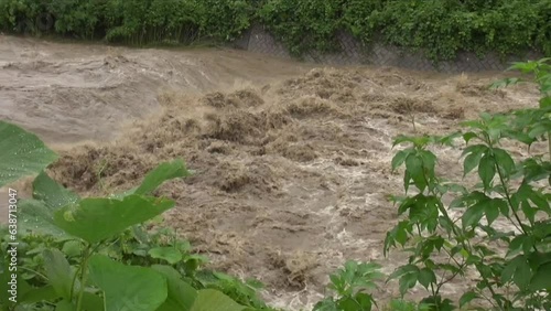 大雨の後に濁流が流れる川
